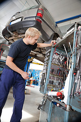 Image showing Mechanic looking at repairing tools