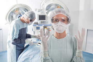 Image showing Female surgeon asking for gloves