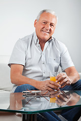 Image showing Senior Man Holding Glass of Orange Juice