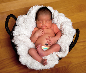 Image showing Cute baby asleep in basket