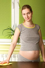 Image showing pregnant woman cleans up the kitchen