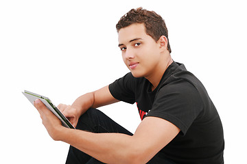 Image showing A smiling man sitting on the floor with a tablet, isolated on wh