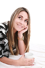 Image showing Smiling woman laying on bed 