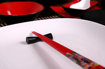 Image showing Red chopsticks on white plate