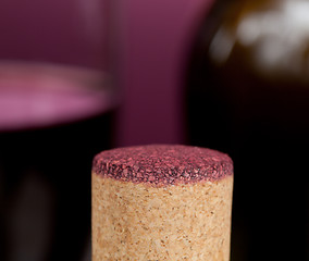 Image showing Red wine soaked cork in front of glass