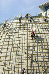 Image showing Closeup of construction worker assembling scaffold on building s