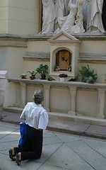 Image showing Pilgrim praying before a crucifix