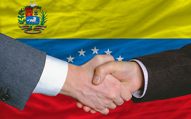 Image showing businessmen handshake after good deal in front of venezuela flag