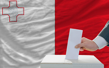 Image showing man voting on elections in malta in front of flag