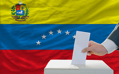 Image showing man voting on elections in venezuela in front of flag