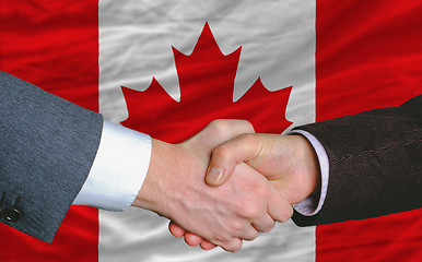 Image showing businessmen handshake after good deal in front of canada flag