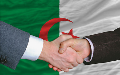 Image showing businessmen handshake after good deal in front of algeria flag