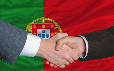 Image showing businessmen handshake after good deal in front of portugal flag