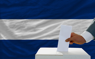 Image showing man voting on elections in nicaragua in front of flag