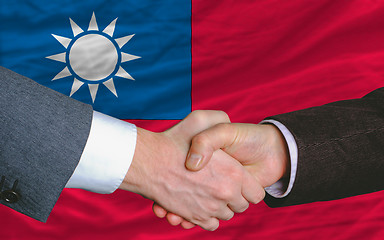 Image showing businessmen handshake after good deal in front of taiwan flag