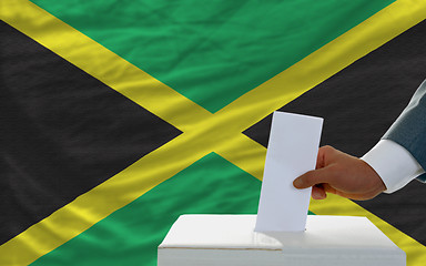 Image showing man voting on elections in jamaica in front of flag