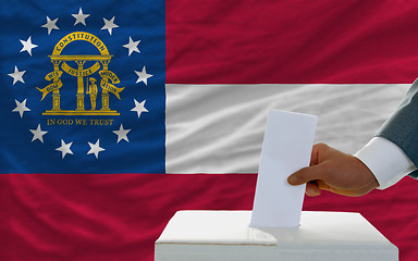 Image showing man voting on elections in georgia in front of flag