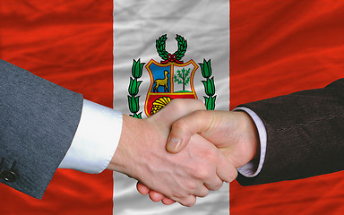 Image showing businessmen handshake after good deal in front of peru flag