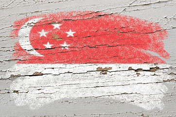 Image showing flag of Singapore on grunge wooden texture painted with chalk  