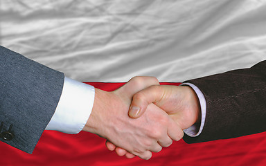 Image showing businessmen handshake after good deal in front of poland flag