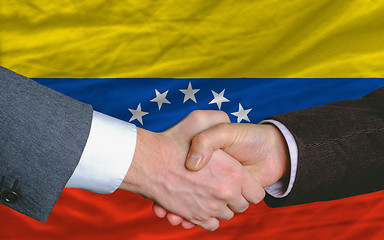 Image showing businessmen handshake after good deal in front of venezuela flag