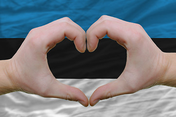 Image showing Heart and love gesture showed by hands over flag of estonia back