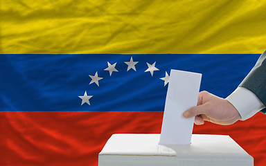 Image showing man voting on elections in venezuela in front of flag