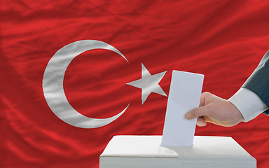 Image showing man voting on elections in turkey in front of flag