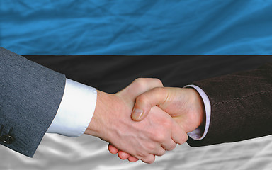Image showing businessmen handshake after good deal in front of estonia flag