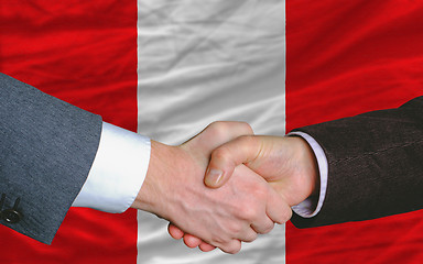 Image showing businessmen handshake after good deal in front of peru flag