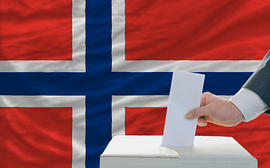 Image showing man voting on elections in norway in front of flag