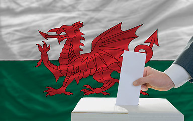 Image showing man voting on elections in wales in front of flag