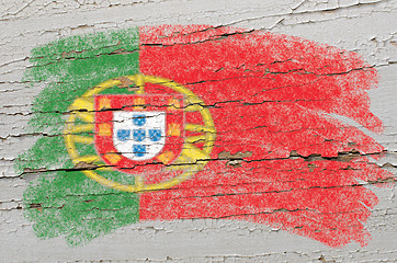 Image showing flag of Portugal on grunge wooden texture painted with chalk  