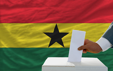 Image showing man voting on elections in ghana in front of flag