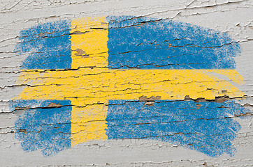 Image showing flag of Sweden on grunge wooden texture painted with chalk  