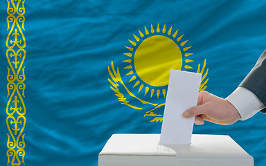 Image showing man voting on elections in kazakhstan in front of flag