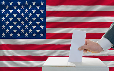 Image showing man voting on elections in america in front of flag