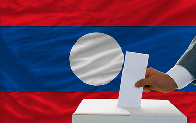 Image showing man voting on elections in laos in front of flag