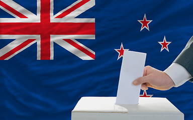 Image showing man voting on elections in new zealand in front of flag