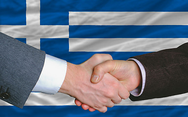 Image showing businessmen handshake after good deal in front of greece flag