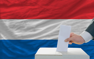 Image showing man voting on elections in netherlands in front of flag