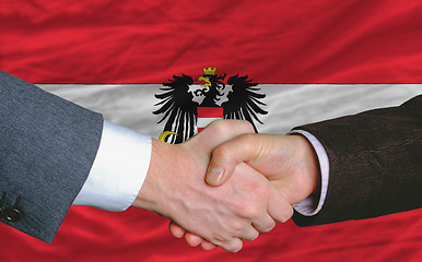 Image showing businessmen handshake after good deal in front of austria flag