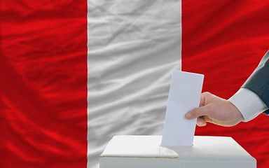 Image showing man voting on elections in peru in front of flag