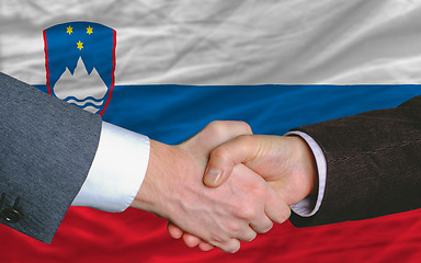 Image showing businessmen handshake after good deal in front of slovenia flag