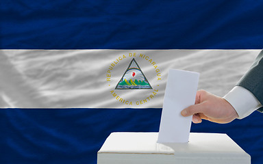 Image showing man voting on elections in nicaragua in front of flag