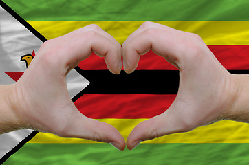 Image showing Heart and love gesture showed by hands over flag of zimbabwe bac