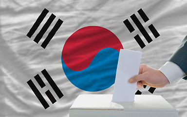 Image showing man voting on elections in south korea in front of flag