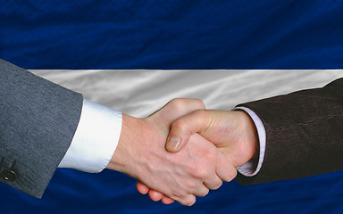 Image showing businessmen handshake after good deal in front of nicaragua flag