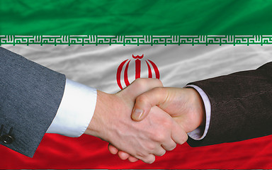 Image showing businessmen handshake after good deal in front of iran flag