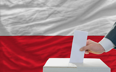 Image showing man voting on elections in poland in front of flag